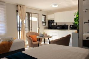 a kitchen and living room with a table and chairs at Viva Guest House in Trevallyn
