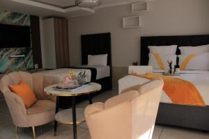 a hotel room with two beds and a table and chairs at Viva Guest House in Trevallyn