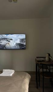 a room with a bed and a television on the wall at Apartmani SARA Bugojno in Bugojno