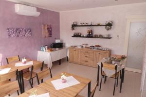 a dining room with wooden tables and a kitchen at La casa di Mazzancollo in San Martino in Pensilis