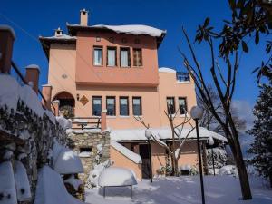 a house with snow on the ground in front of it at Villa Aglaini in Agios Dimitrios