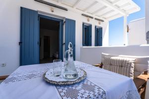 a table with a glass vase on a white table cloth at Terraegea Paros in Dhragoulás