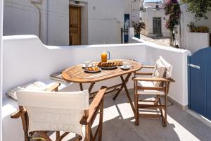 a table and chairs on a balcony with a candle at Terraegea Paros in Dhragoulás