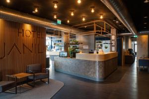 a lobby of a restaurant with a counter and chairs at Hotel DEJANIL Hannover Burgdorf in Burgdorf