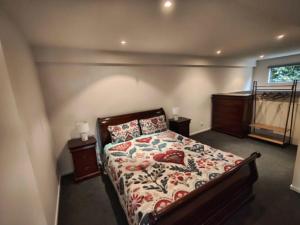 a bedroom with a bed with a floral bedspread at Enkindled Haven in Moonah