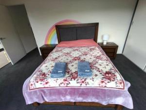 a bedroom with a bed with a rainbow on the wall at Enkindled Haven in Moonah