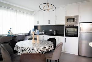 a kitchen with a table with chairs and a refrigerator at Villa Aki in Posedarje