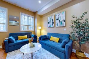 a living room with two blue couches and a table at Private Rooftop Group Suite near Oriole Park - Eglinton Hotel in Toronto