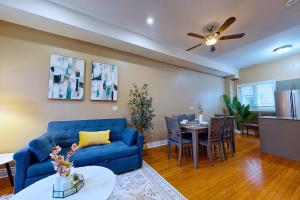 a living room with a blue couch and a table at Private Rooftop Group Suite near Oriole Park - Eglinton Hotel in Toronto +19 photos