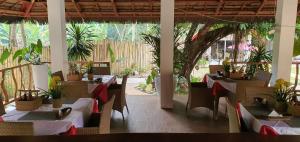 a restaurant with tables and chairs and potted plants at lala-Oh Resort in Lalao