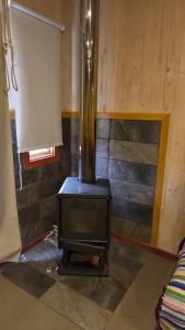 a woodburning stove in a room with a couch at Casa primera linea de playa in Maricó