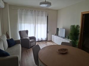 a living room with a table and a couch and a tv at Apartamento en Moraira Centro con Piscina in Moraira