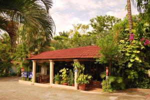 un petit bâtiment avec un toit rouge dans l'établissement Hotel La Hacienda, à Tuxtla Gutiérrez