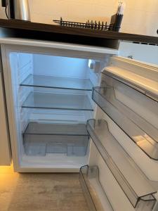 an empty refrigerator with its door open in a kitchen at Cozy mini-apartment with kitchen in Åmot