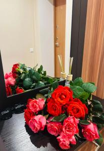 a bouquet of red roses sitting on a table at Levandų šeimyniniai apartamentai su vonia ir sodu in Ryškėnai +14 photos