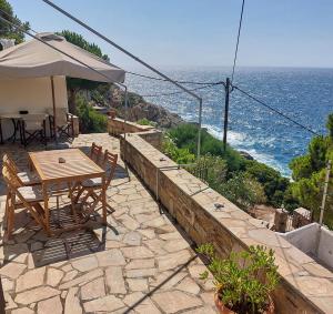 a patio with a table and chairs and the ocean at Captain's View Guesthouse in Kouniádhoi