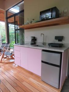 a kitchen with pink cabinets and a counter top at Ruca Lodge -Luxury Cabins Nestled in Nature in Uvita