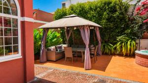 a gazebo with a table and chairs on a patio at Vila Olivença in Costa da Caparica