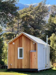 ein Holzgebäude mit einem Fenster auf einem Feld in der Unterkunft LANÍN Tiny House in San Martín de los Andes + 21 Fotos
