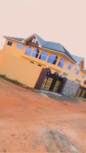 a yellow building with windows on the side of it at Abronoma Guest House in Ogbojo