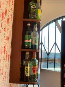 a shelf with several bottles of alcohol on it at Abronoma Guest House in Ogbojo