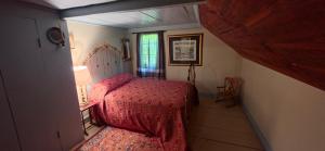 a small bedroom with a bed and a window at JOSIAH KEITH HOUSE museum & inn in Five Corners