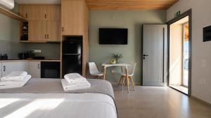 ein Schlafzimmer mit einem Bett und eine Küche mit einem Tisch in der Unterkunft BluWave in Kómi