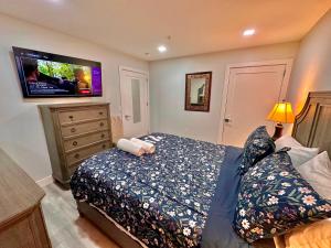 a bedroom with a bed and a flat screen tv at The Elegant Suite - 2BR with Great Amenities in Paterson