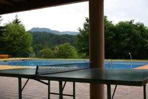 a tennis racket sitting on a table in front of a pool at Camping Vidrà in Vidrá