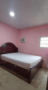 a bedroom with a large bed in a pink wall at La parada de Emma in Las Lomas