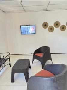 a room with two chairs and a tv on a wall at Apartamento comodo en Rivas in Rivas