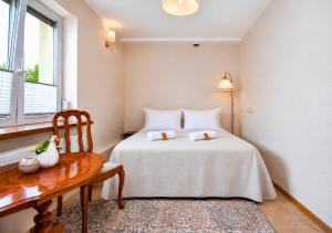 a bedroom with a bed and a table and a window at KUBU Loft in Klaipėda