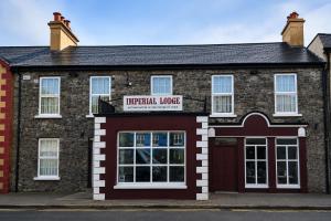 a red brick building with a red garage at Imperial Lodge in Lisdoonvarna