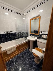 a bathroom with a tub and a toilet and a sink at Imperial Lodge in Lisdoonvarna