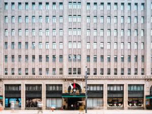 a large beige building with many windows at Fairmont Peace Hotel on the Bund in Shanghai +280 photos