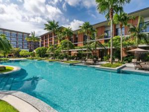 a large swimming pool in front of a hotel at Pullman Khao Lak Resort in Khao Lak