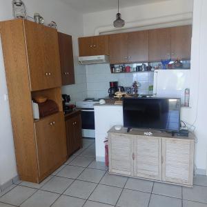 a kitchen with a television on a table in a kitchen at Captain's View Guesthouse in Kouniádhoi
