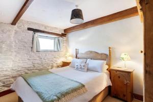 a bedroom with a bed and a stone wall at 2 Bed in Ambleside oc-lr177 in Ambleside +28 photos