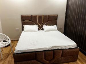 a bedroom with a large bed with a wooden headboard at Luxe Farm in Greater Noida +7 photos