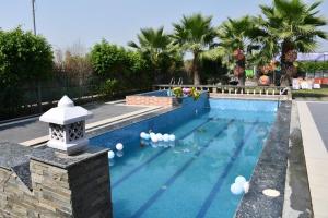 a swimming pool with white balls in the water at Luxe Farm in Greater Noida