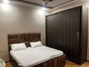 a bedroom with a large bed and a black closet at Luxe Farm in Greater Noida