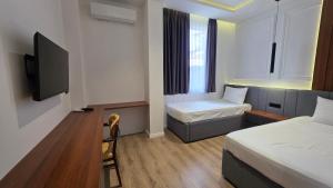 ein Hotelzimmer mit zwei Betten und einem Fernseher in der Unterkunft Hotel Velaris in Struga