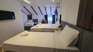 ein Hotelzimmer mit zwei Betten und einem Fernseher in der Unterkunft Hotel Velaris in Struga + 9 Fotos