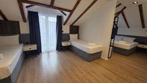 ein großes Zimmer mit zwei Betten und einem Fenster in der Unterkunft Hotel Velaris in Struga