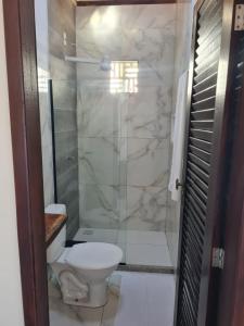 a bathroom with a toilet and a glass shower at Canto das Praieiras - Porto de Sauípe, Rio & Mar in Porto de Sauipe