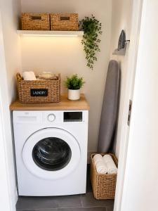 a washer and dryer in a laundry room with baskets at Dunmore East Studio in Rathmoylan