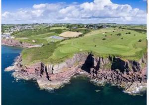 an aerial view of a golf course on cliffs next to the ocean at Dunmore East Studio in Rathmoylan