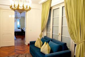 a living room with a blue couch and a chandelier at Villa Dedinje in Belgrade +62 photos