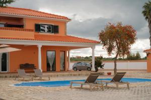 a pool in front of a house with chairs at Quinta da Shambhala in Soriço
