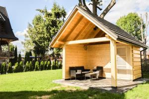 a shed with chairs and a table in a yard at Domek Za Dworem in Witów +24 photos